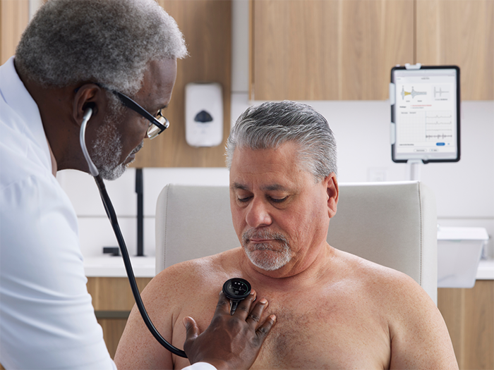 Clinician uses CORE 500™ to listen to patient's heart